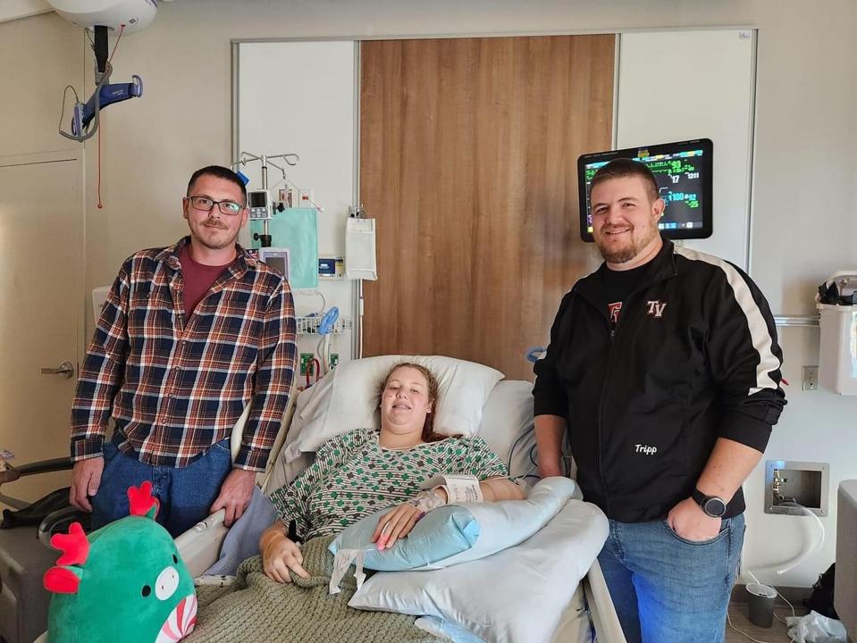 Brynn Goedel, a student at Tuscarawas Valley High School who was injured in a school bus crash on Nov. 14, is shown with Josh Chieka, left, a truck driver who pulled her from the bus, and Stephen Tripp, Tusky Valley's middle school band director.