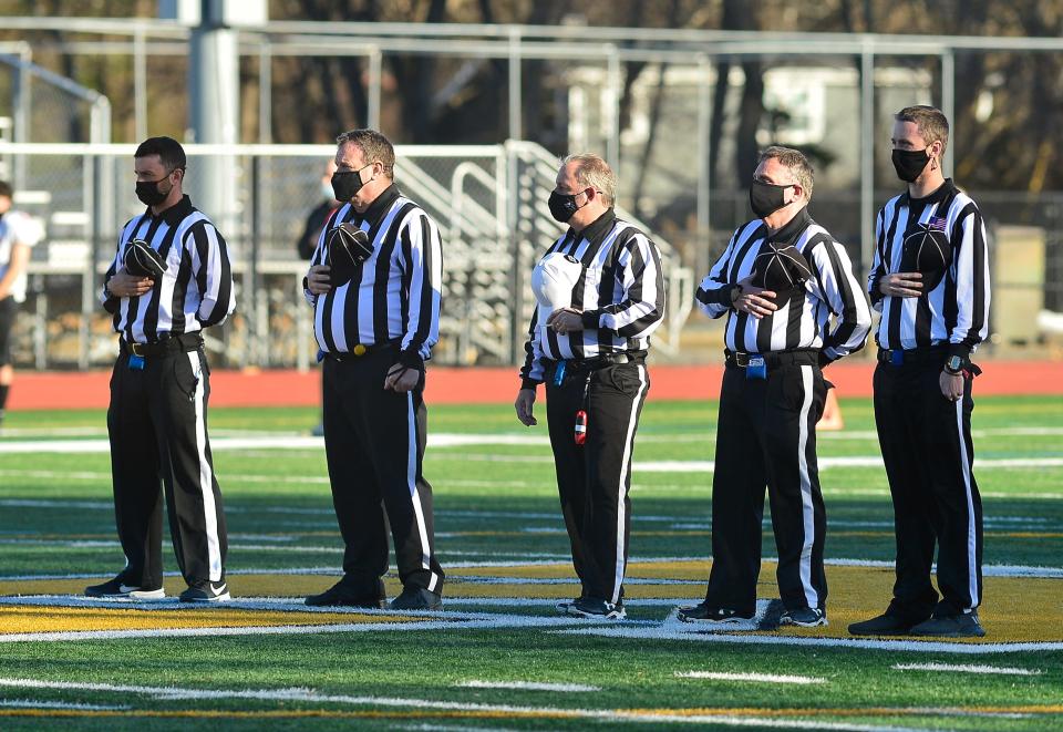 In this file photo, referees stand as the national anthem is played for a Taunton football game against King Philip.