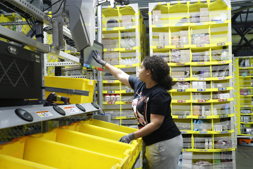 FILE - In this June 26, 2019, file photo a worker sorts through items and places orders at the Amazon Fulfillment Center in Staten Island in New York. Amazon.com Inc. reports financial earns on Thursday, Oct. 24. (AP Photo/Kathy Willens, File)