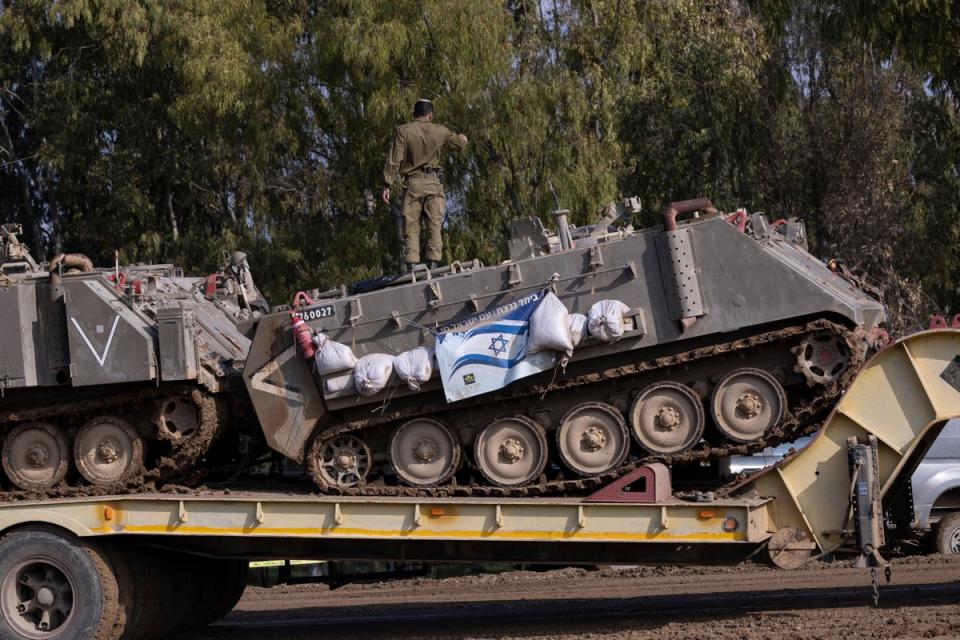 Israeli soldiers load a tank near the border to Gaza (Getty)