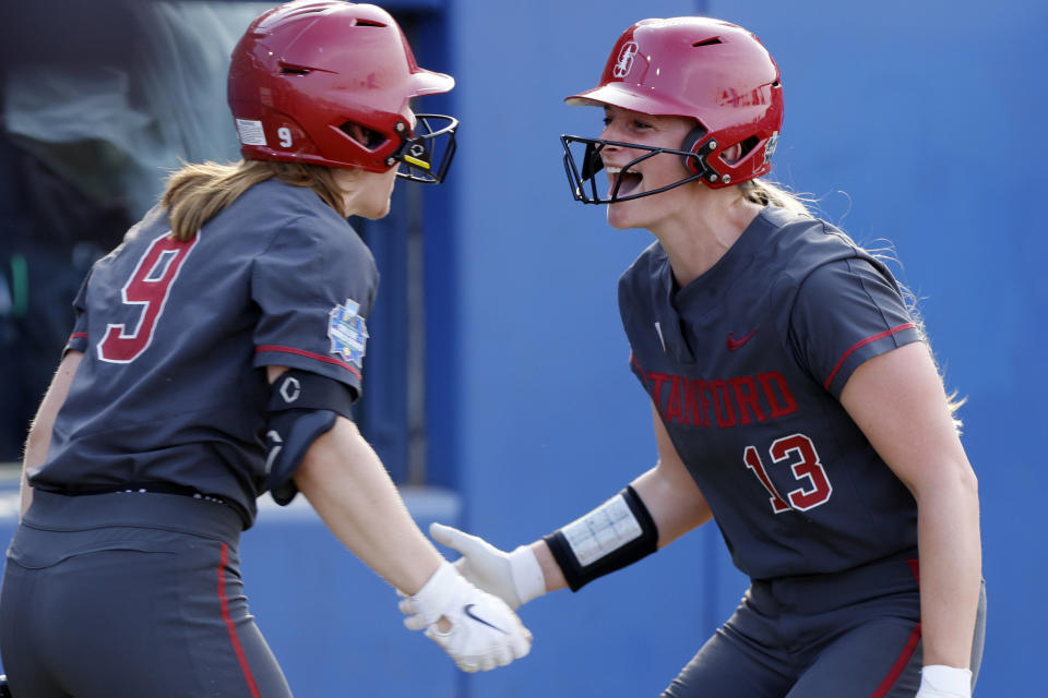 Stanford's Ellee Eck (9) and Emily Schultz celebrate after Schultz scored against Alabama during the second inning of an NCAA softball Women's College World Series game Friday, June 2, 2023, in Oklahoma City. (AP Photo/Nate Billings)