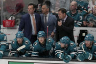 San Jose Sharks head coach David Quinn, standing left, leaves the bench area after being ejected during the third period of the team's NHL hockey game against the Washington Capitals in San Jose, Calif., Saturday, March 4, 2023. (AP Photo/Jeff Chiu)