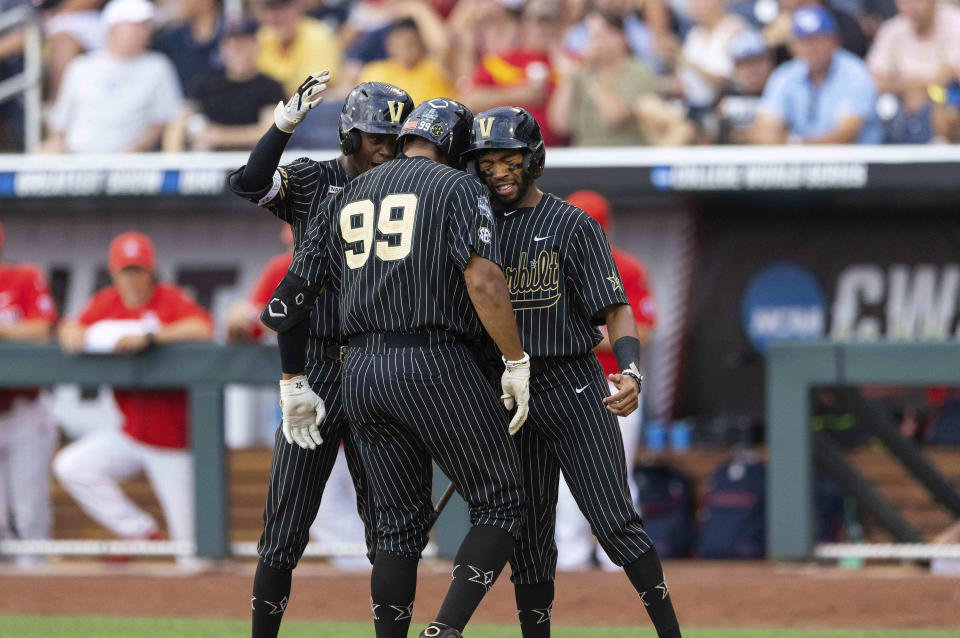 Vanderbilt's Jayson Gonzalez (99), center, celebrates with Enrique Bradfield Jr., left, and Javier Vaz, right, after hitting a two-run home run against Arizona in the fourth inning during a baseball game in the College World Series, Saturday, June 19, 2021, at TD Ameritrade Park in Omaha, Neb. (AP Photo/Rebecca S. Gratz)