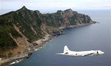 Japan Maritime Self-Defense Force's PC3 surveillance plane flies around the disputed islands in the East China Sea, known as the Senkaku isles in Japan and Diaoyu in China, in this October 13, 2011 file photo. REUTERS/Kyodo/Files