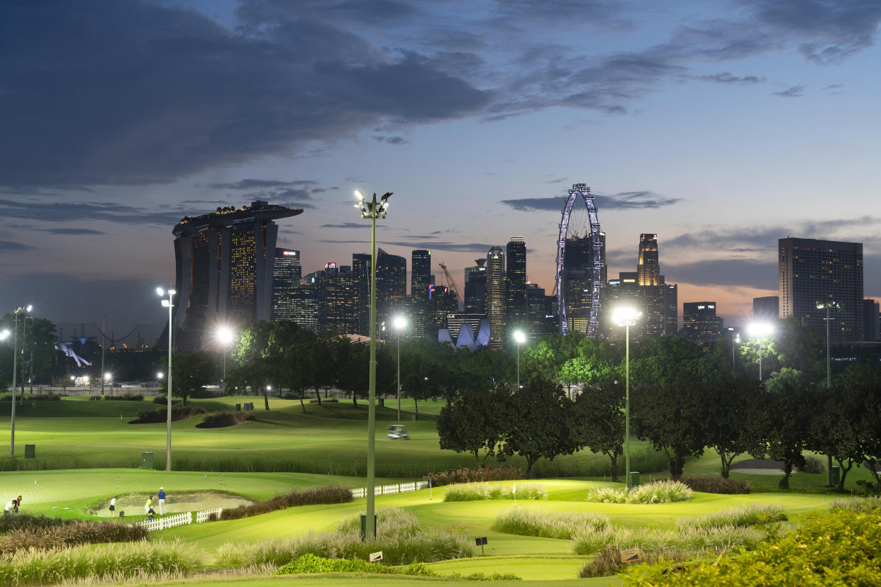 Golfers play in the evening at the Marina Bay Golf Course in Singapore in 2021. (Photographer: Wei Leng Tay/Bloomberg)