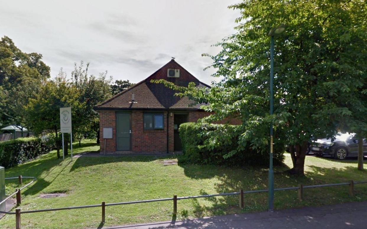 A picture of a brown brick health centre surrounded by lawn and trees