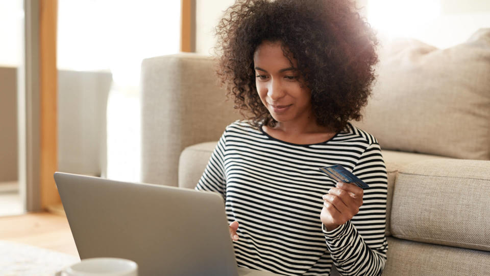 Shot of a young woman using her credit card to make an online payment at homehttp://195.