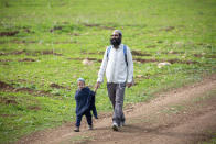 In this Friday, Feb. 21, 2020 photo, a settler and his son walk during the annual Jordan Valley parade, in the Jordan Valley. Israel's prime minister is eager to court the votes of the country's influential West Bank settlers in critical elections next month. President's Donald Trump's Mideast plan seemed to be the key to ramping up their support. The plan envisions Israel's eventual annexation of its scores of West Bank settlements — a long time settler dream. But in the weeks since it was unveiled, Israeli Prime Minister Benjamin Netanyahu has stumbled over his promises to quickly carry out the annexation, sparking verbal attacks from settler leaders. (AP Photo/Ariel Schalit)