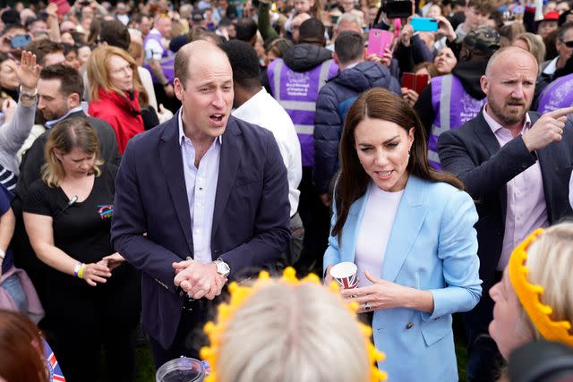 <p>Andrew Matthews-WPA Pool/Getty</p> Prince William and Kate Middleton they speak to people during a walkabout meeting members of the public on the Long Walk near Windsor Castle on May 7.