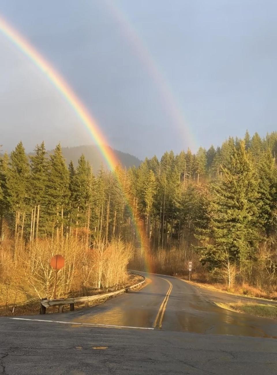 The end of a rainbow on a road