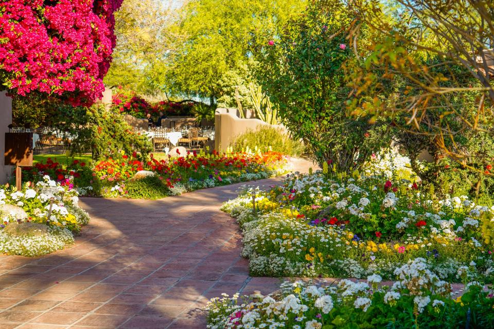 A brick path in a vibrant garden at Hermosa Inn