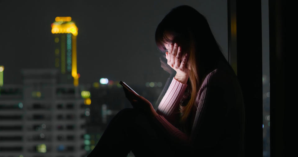 woman use phone and feel depression at night