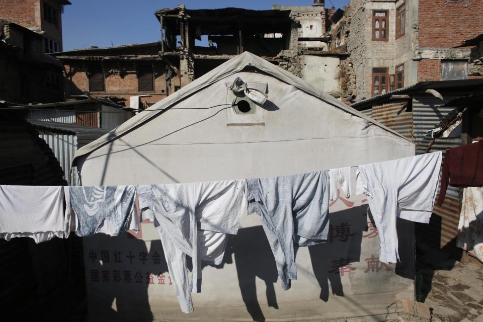 Clothes are hung on a line to dry in front of houses damaged by the 2015 earthquake in Bhaktapur, Nepal, Wednesday, Jan. 4, 2017. People who lost their homes in the devastating earthquake that hit Nepal nearly two years ago are tired of waiting for help to rebuild. The slow pace of distributing government grant money for rebuilding has left many people to spend their second winter without a home. (AP Photo/Niranjan Shrestha)