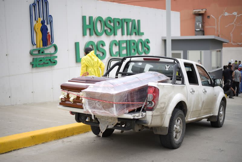 Funeral home employees wait with coffins on a pick-up truck outside Los Ceibos hospital after Ecuador reported new cases of coronavirus disease (COVID-19), in Guayaquil