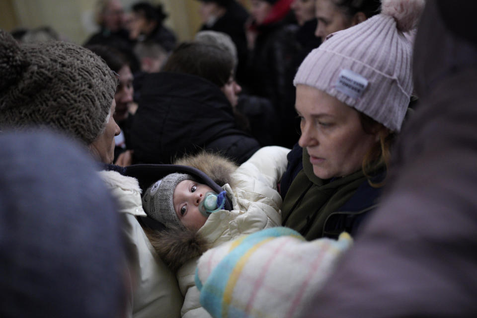 A woman holds he baby after fleeing the conflict from neighboring Ukraine at the Przemysl train station in Przemysl, Poland, Wednesday, March 9, 2022. (AP Photo/Daniel Cole)