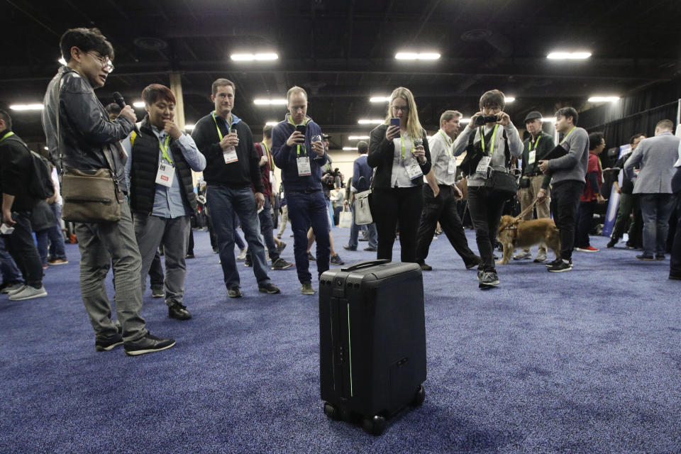 Attendees take pictures of ForwardX Robotics’ CX-1 self-driving luggage during CES Unveiled at CES International Sunday, Jan. 7, 2018, in Las Vegas. (AP Photo/Jae C. Hong)