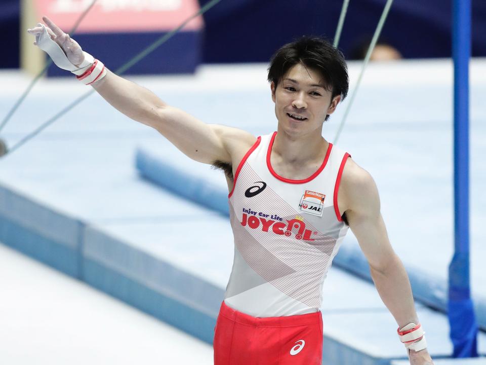 Kohei Uchimura raises his hand at a meet in 2021.