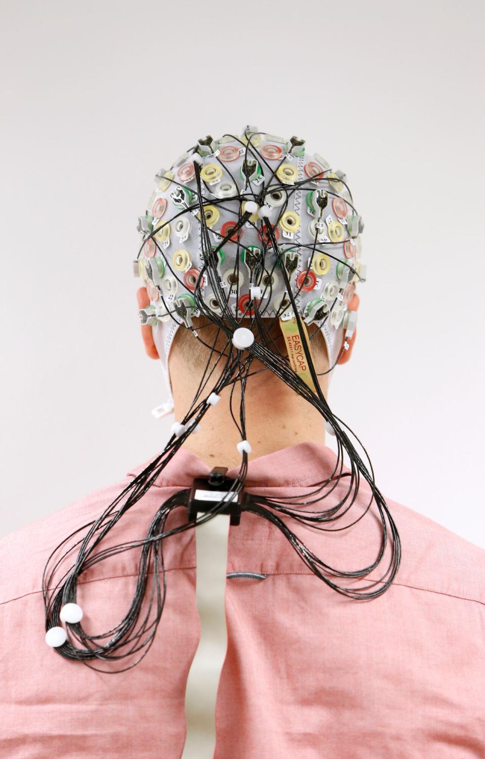 Test subject Niklas Thiel poses with an electroencephalography (EEG) hood that measures brain activity at the Technische Universitaet Muenchen (TUM) in Garching near Munich, September 9, 2014. 