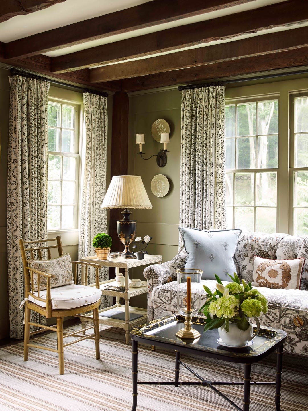 a dining room conversation corner with pretty patterned curtains and a sofa, coffee table and chair