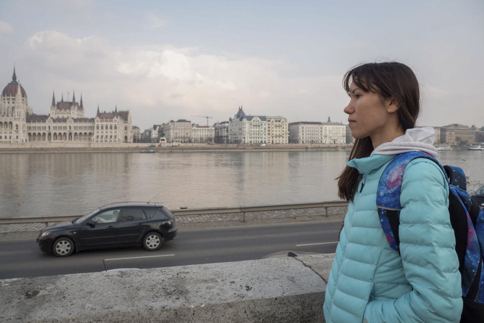 Olena, a Russian citizen fleeing from Kyiv, Ukraine (no family name given for safety reason) looks at the Hungarian Parliament building and the River Danube in downtown Budapest on Friday, March 4, 2022. Olena who years ago left her home country in opposition to Vladimir Putin's government has been forced to flee again — this time from her adopted home of Kyiv — as Putin's armed forces assault Ukraine. (AP Photo/Balazs Kaufmann)