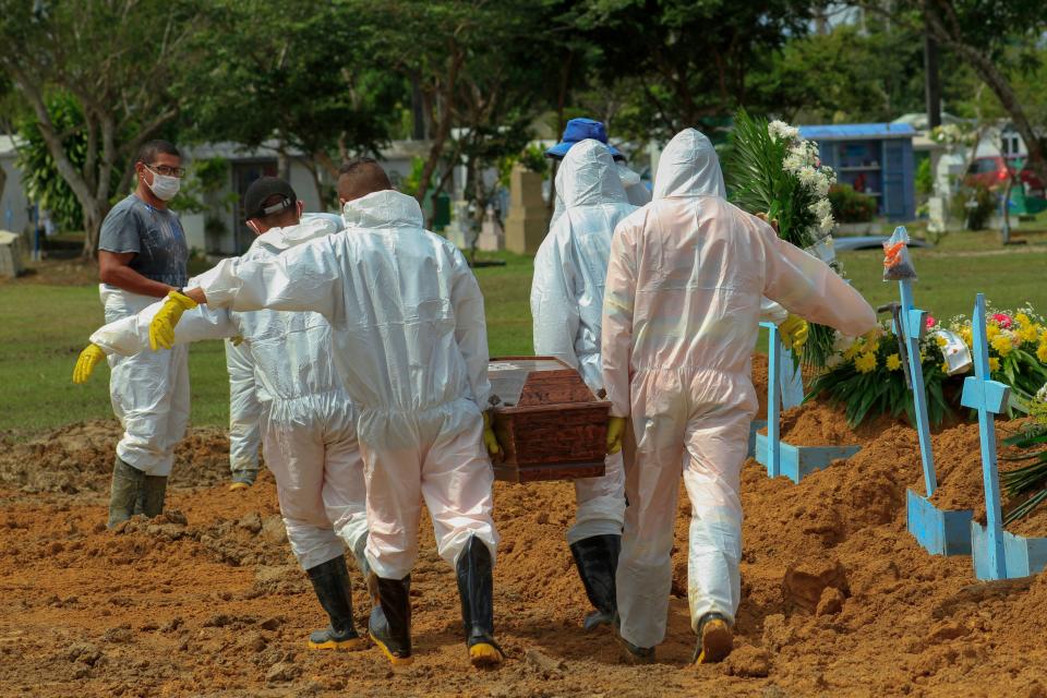 Gravediggers carry the coffin of a COVID-19 victim at the Nossa Senhora Aparecida cemetery in Manaus, Amazonas state, Brazil, on January 22, 2021, amid the novel coronavirus pandemic. (Marcio James/AFP via Getty Images)