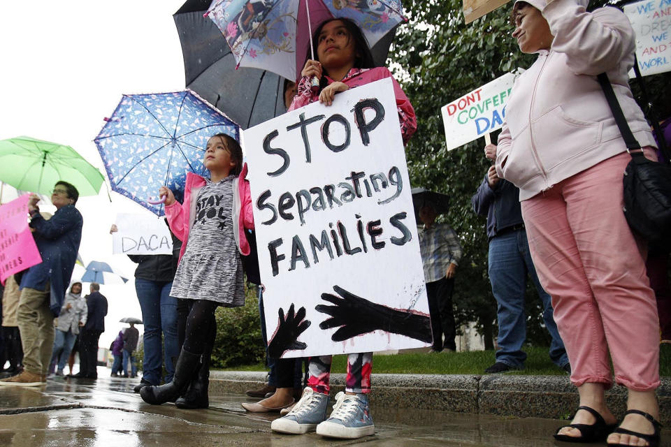 FILE – In this Sept. 7, 2017 file photo, April Soasti, 9, front, and her sister Adriana, 7, stand with other community members after the president announced the plan to repeal of the Deferred Action in Childhood Arrivals (DACA) program on Tuesday. Six immigrants brought to the United States as children who became teachers, graduate students and a lawyer are suing the Trump administration over its decision to end DACA, which is shielding them from deportation. (Stephanie Zollshan/The Berkshire Eagle via AP, File)