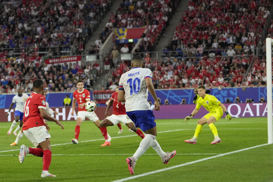 Kylian Mbappe of France crosses the ball before Austria's Maximilian Wober scores an own goal during a Group D match between Austria and France at the Euro 2024 soccer tournament in Duesseldorf, Germany, Monday, June 17, 2024. (AP Photo/Andreea Alexandru)