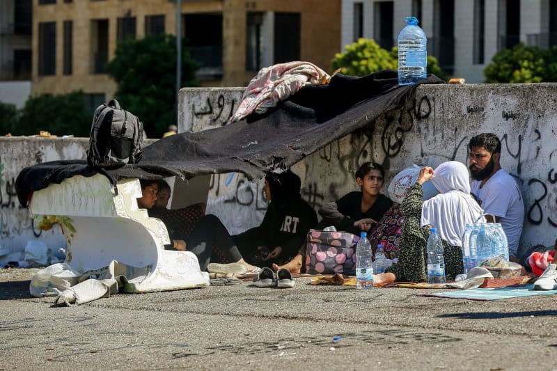 A Syrian refugee family who fled Beirut's southern suburbs rests under a makeshift tent on the street in Beirut's Martyrs' Square. Hundreds of Syrian and Lebanese families left the southern suburb, a hotbed for the pro-Iranian party Hezbollah, after Israel launched massive airstrikes against leader Hassan Nasrallah. Marwan Naamani/dpa