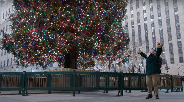 <p>Saturday Night Live/Youtube</p> Kate McKinnon in front of the Rockefeller Christmas tree