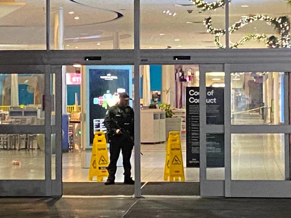 A police office guards an entrance to the Tacoma Mall on Friday. Gunshots rang out in the shopping center earlier in the evening.