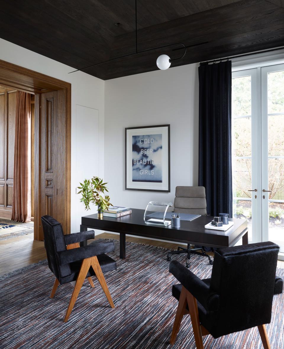 “His aesthetic is a little more modern, so this was our chance to create a more contemporary look,” says Mann of the dark-stained ceiling in Jeffrey Quicksilver’s office. Black hair-on-hide upholstery on the Pierre Jeanneret chairs picks up on the dark tones in the leather, wool, and suede rug by Toyine Sellers.