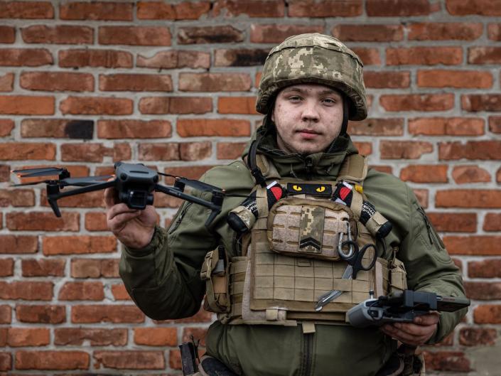 A Ukrainian soldier holding a drone