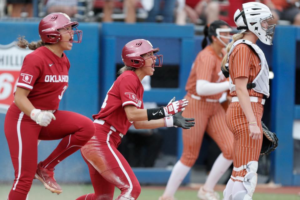 OU's Jayda Coleman, center, and Alyssa Brito (33) celebrate after Coleman scored a run in the first inning of a 5-1 win against Texas in the Big 12 softball tournament championship game on Saturday night at Devon Park.