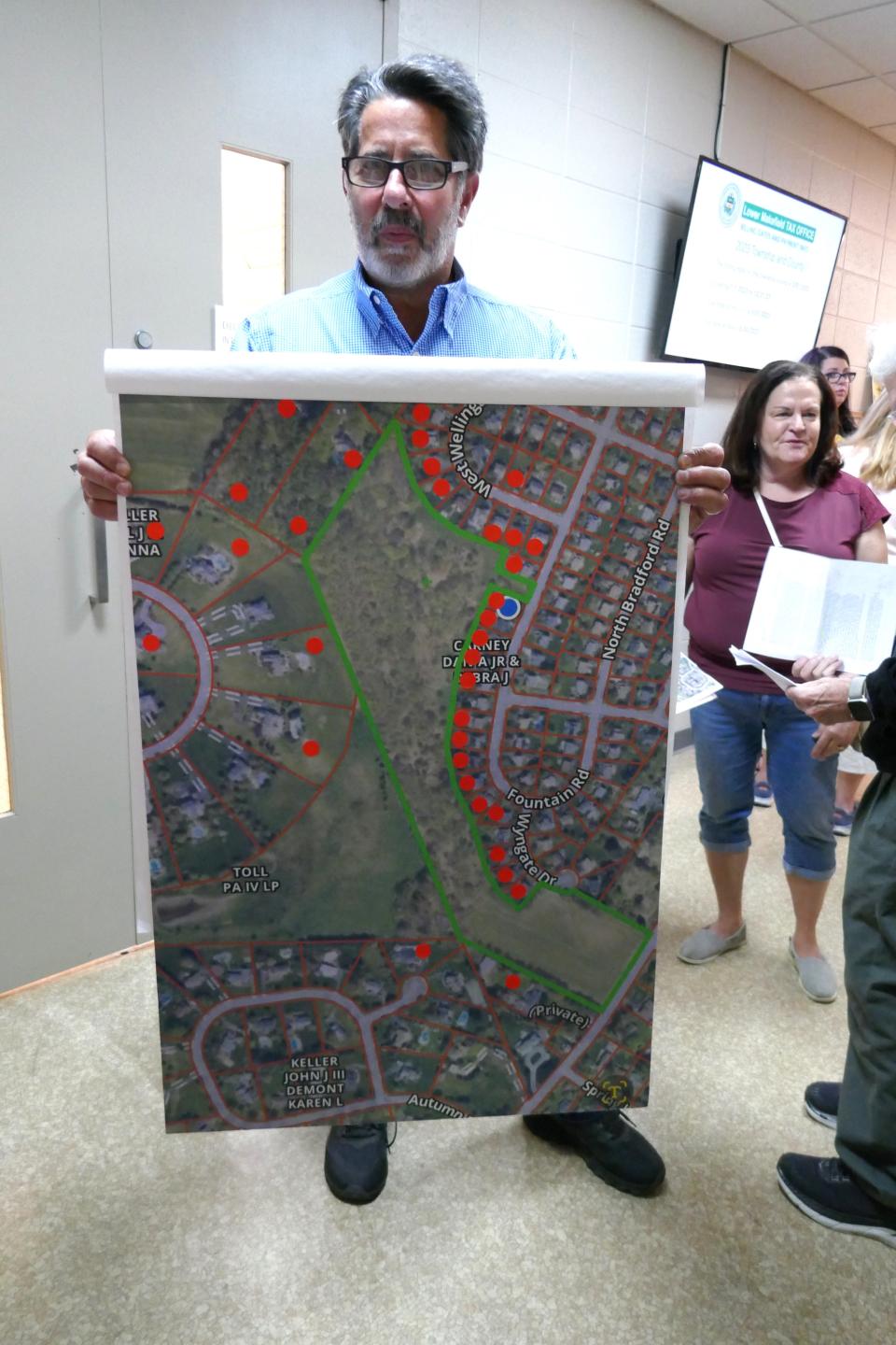 Rob Ottenheimer shows a map of the area between housing developments where archers wanted to hold a deer hunt but the Lower Makefield supervisors said it wouldn't take place in that location after neighbors opposed it at a supervisors' board meeting Wednesday night.  The red dots represent residents who petitioned against the hunt.