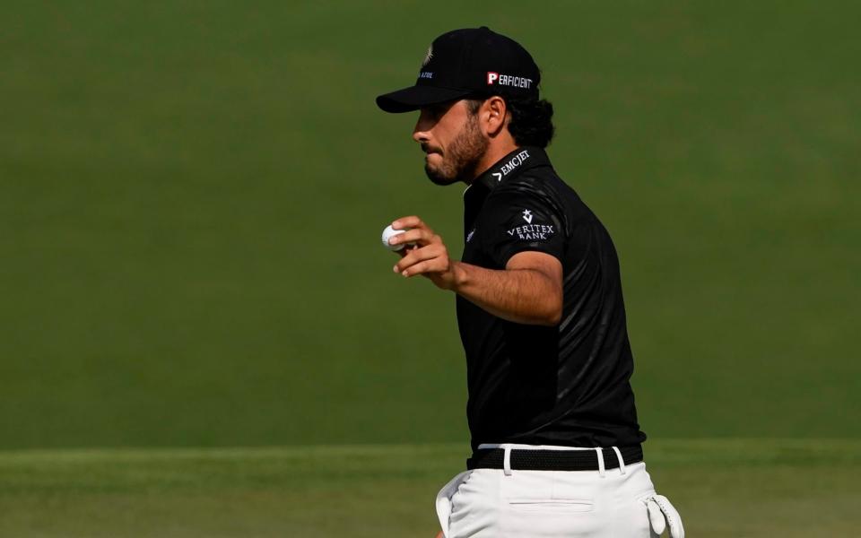Abraham Ancer, of Mexico, holds up his ball after putting on the second hole during the first round of the Masters golf tournament on Thursday, April 8, 2021, in Augusta - AP/Gregory Bull&#xa0;
