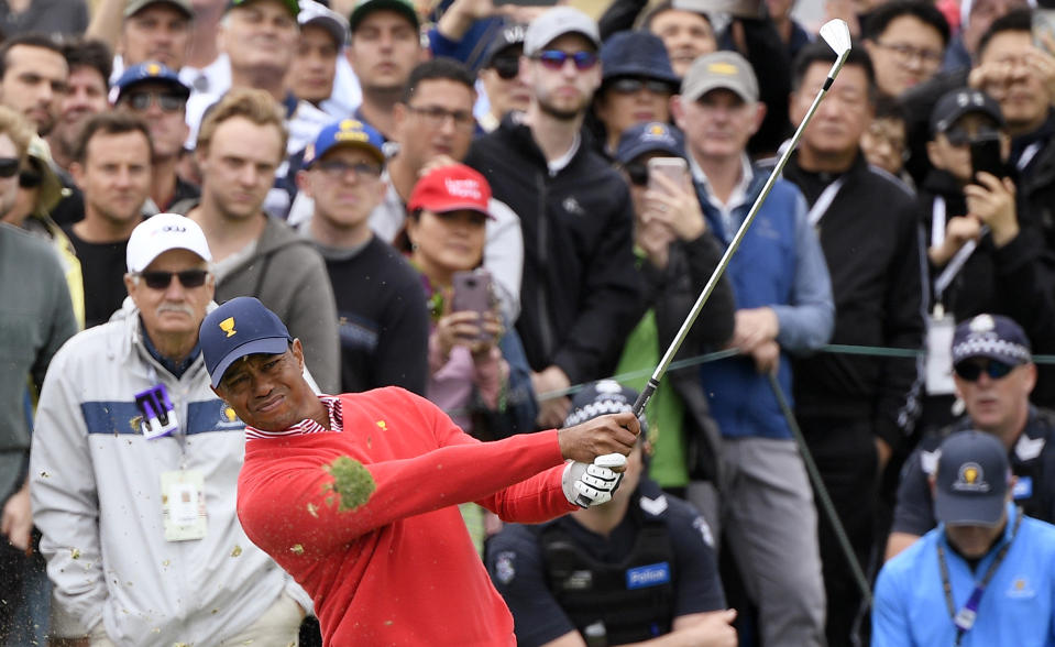 U.S. team player and captain Tiger Woods watches his sceond shot on the 7th hole as the turf flies up during their fourball match at the Royal Melbourne Golf Club in the opening rounds of the President's Cup golf tournament in Melbourne, Thursday, Dec. 12, 2019. (AP Photo/Andy Brownbill)