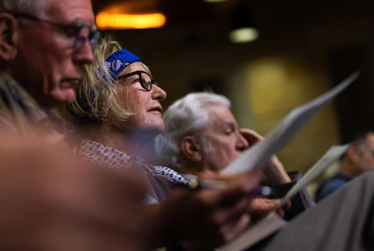 An attendee listens and takes notes as people testify during an Austin city council meeting  on Thursday, May 16, 2024 in Austin. Attendees spent hours at Austin City Hall as the council went through numerous testimonies.