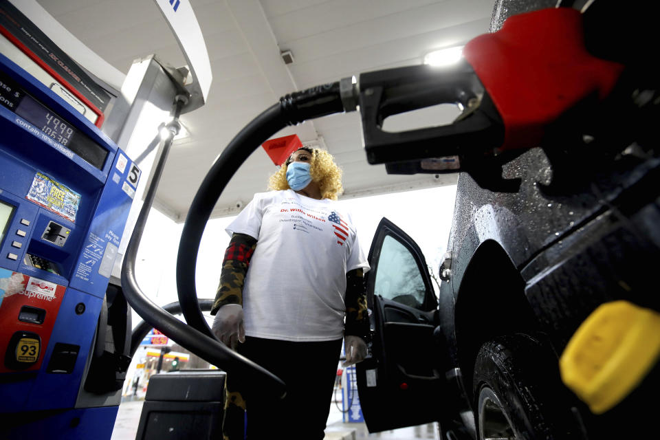 Simone Brooks pumps free gas donated by Willie Wilson at the Mobil Gas Station along Green Bay Road on Thursday, March 24, 2022, in Evanston. (Stacey Wescott/Chicago Tribune via AP)