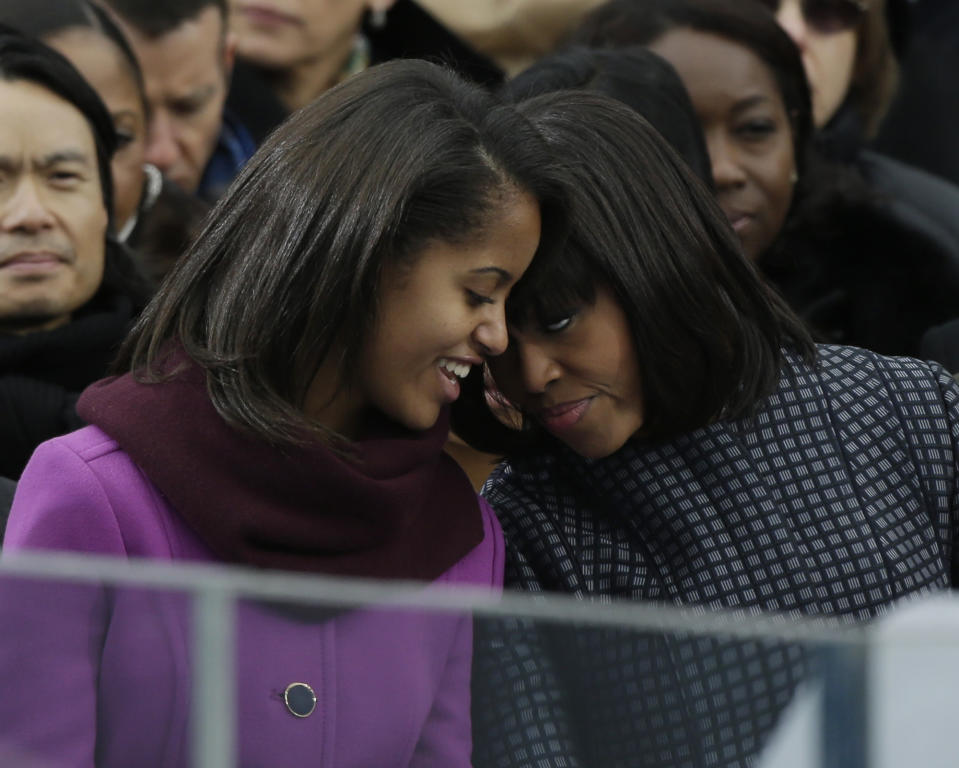 First lady Michelle Obama speaks with her daughter Sasha at the ceremonial swearing-in for President Barack Obama at the U.S. Capitol during the 57th Presidential Inauguration in Washington, Monday, Jan. 21, 2013. (AP Photo/Pablo Martinez Monsivais)