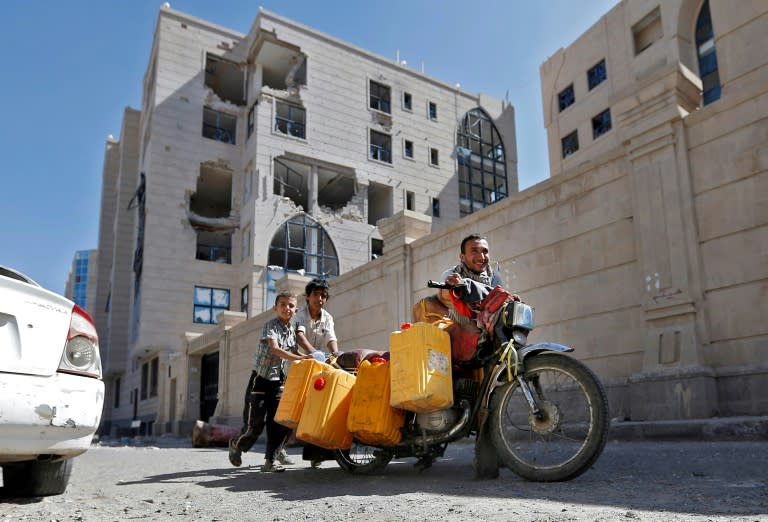 Yemenis push a motorcycle loaded with jerrycans down a street leading to the residence of Yemen’s late ex-president Ali Abdullah Saleh in the capital Sanaa on December 6, 2017