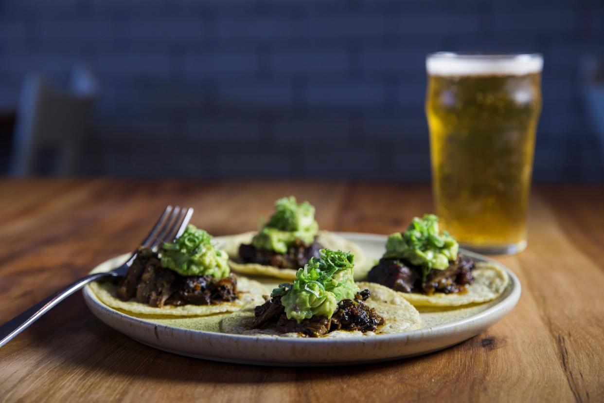 The Suadero Tacos at Suerte are made with confit brisket, black magic oil and avocado salsa cruda.