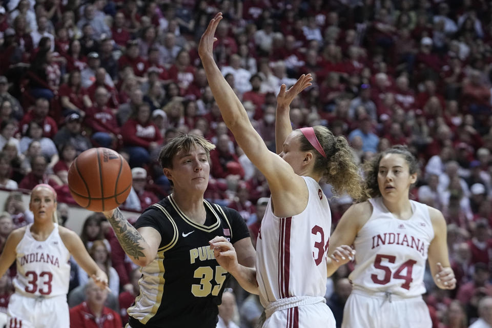 Purdue's Rickie Woltman (35) passes against Indiana's Grace Berger (34) during the first half of an NCAA college basketball game, Sunday, Feb. 19, 2023, in Bloomington, Ind. (AP Photo/Darron Cummings)