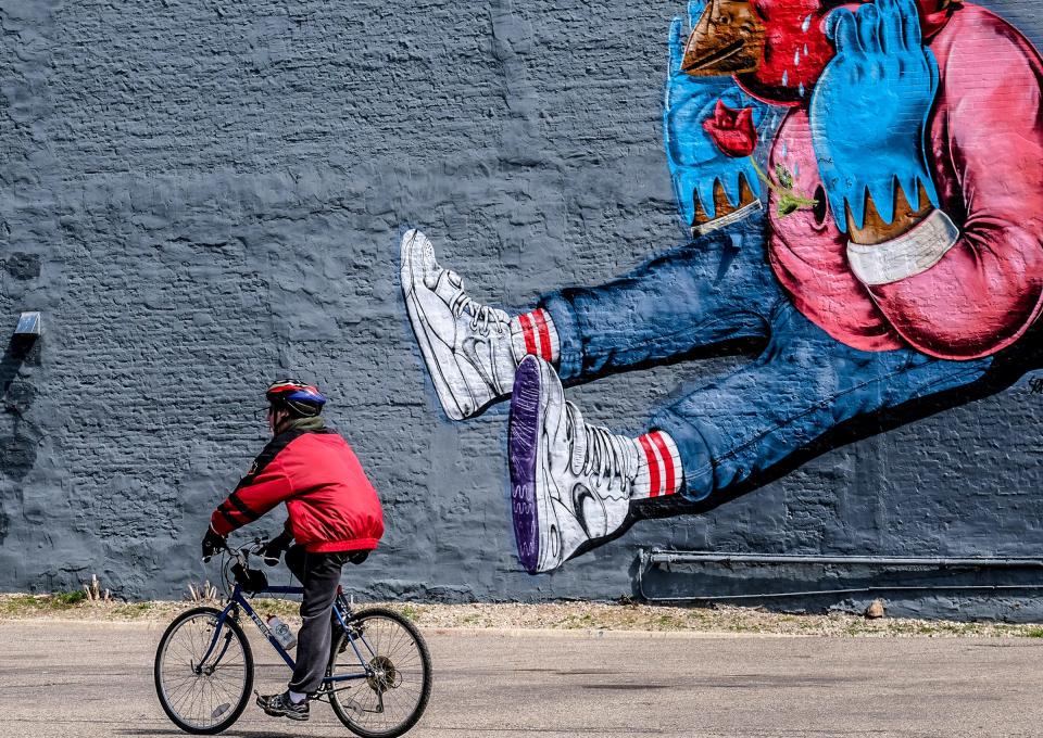 A man rides a bike in Lansing's Old Town Sunday, April 5, 2020. 