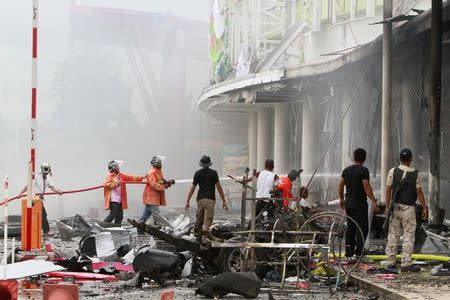 Firefighters douse a fire after a bomb exploded at a supermarket in the city of Pattani, Thailand, May 9, 2017. REUTERS/Surapan Boonthanom