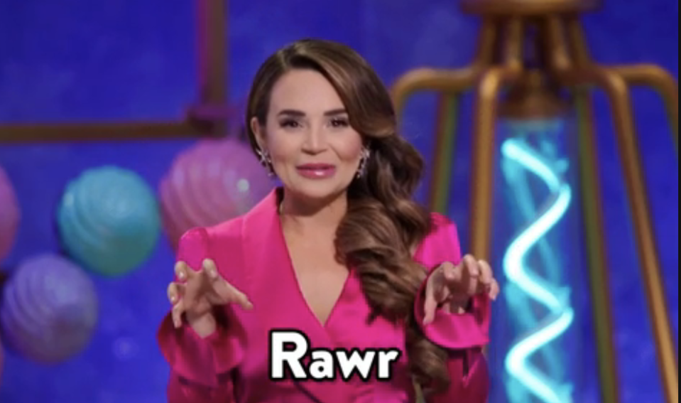 Woman in pink top makes claw gesture, speech bubble says "Rawr"