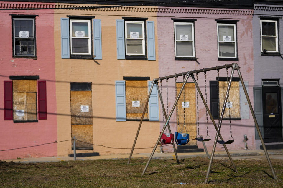 Boarded doors and windows are seen on homes adjacent to a playground, Wednesday, Feb. 15, 2023, in Baltimore. In 2018, Angela Banks was told by her landlord that Baltimore officials were buying her family's home of four decades, planning to demolish the three-story brick rowhouse to make room for an urban renewal project aimed at transforming their historically Black neighborhood. Banks and her children became homeless almost overnight. Banks filed a complaint Monday asking federal officials to investigate whether Baltimore's redevelopment policies are perpetuating racial segregation and violating fair housing laws by disproportionately displacing Black and low-income residents. (AP Photo/Julio Cortez)