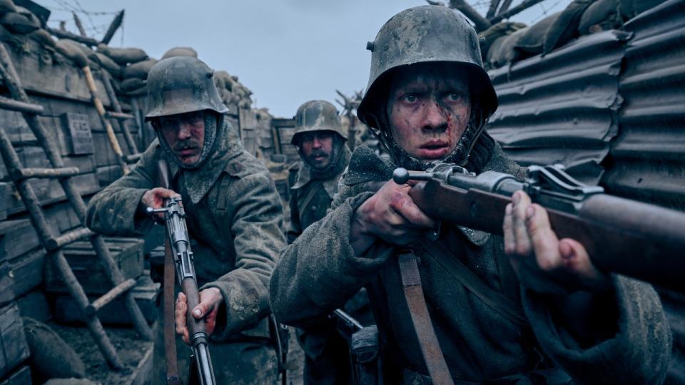 Felix Kammerer, Albrecht Schuch, Edin Hasanovic walking through a trench with guns in All Quiet on the Western Front