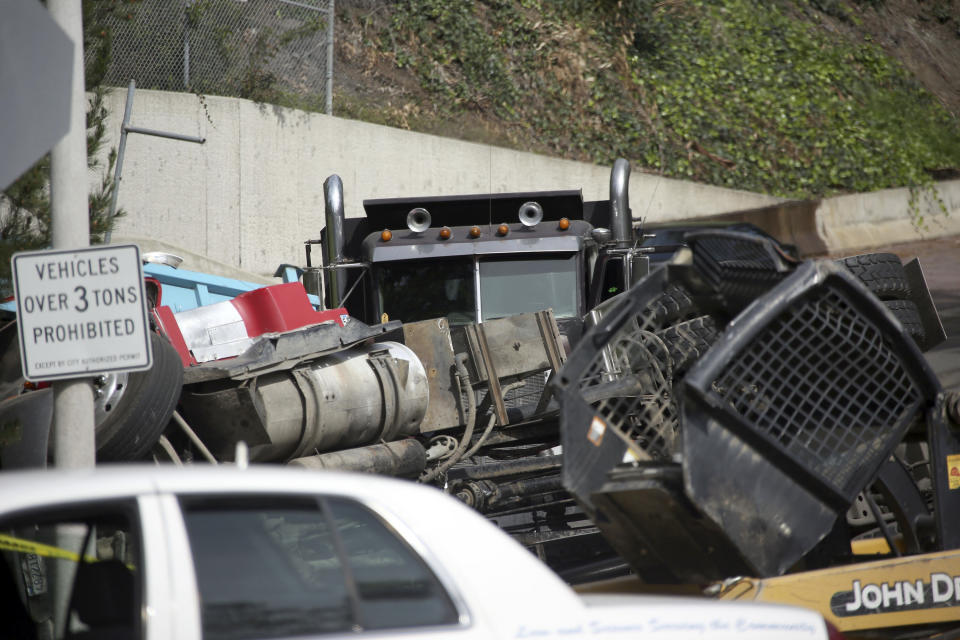 A truck is mangled at the scene of a wreck Friday March 7, 2014 in Beverly Hills, Calif. A veteran Los Angeles police officer was killed and his rookie partner was critically injured Friday when their patrol car collided with a big rig on a residential street. The truck driver also was injured. The Hollywood division officers were responding to a call of unknown trouble when the “catastrophic” collision occurred, Los Angeles Police Chief Charlie Beck said. (AP Photo/Nick Ut )