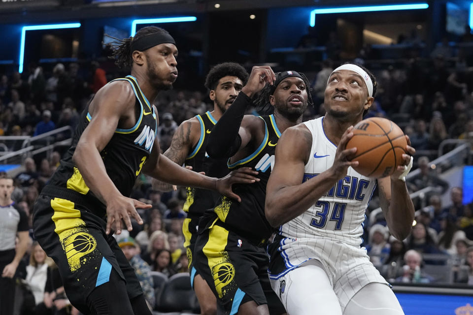 Orlando Magic's Wendell Carter Jr. (34) looks to the basket as Indiana Pacers' Myles Turner, left, and Buddy Hield defend during the first half of an NBA basketball game Saturday, Dec. 23, 2023, in Indianapolis. (AP Photo/Darron Cummings)