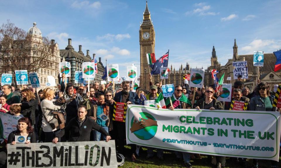 Protesters and migrant workers hold banners and flags as they demonstrate outside parliament to highlight their contribution to the UK economy